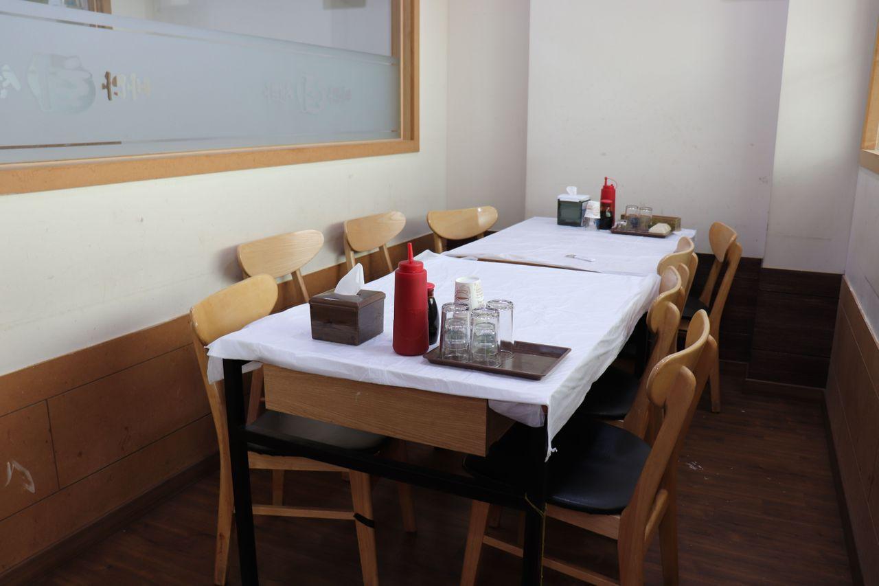 Interior del Sea Fish Center en el Mercado de Pescado de Noryangjin, mostrando mesas preparadas para los clientes.