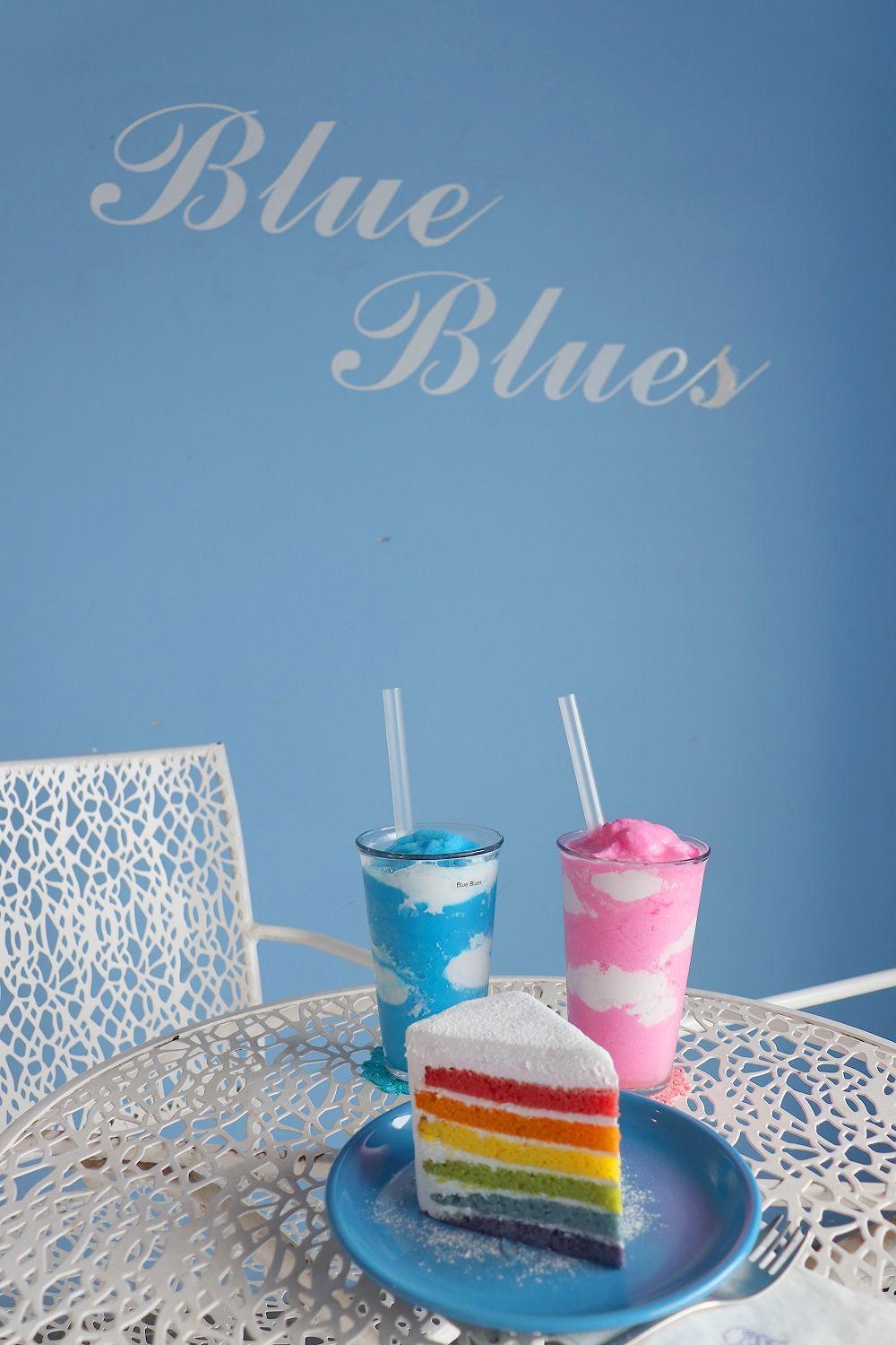 大邱Blue Blues咖啡廳的標誌,店內桌上擺放著彩虹蛋糕和兩杯sky blue飲品。