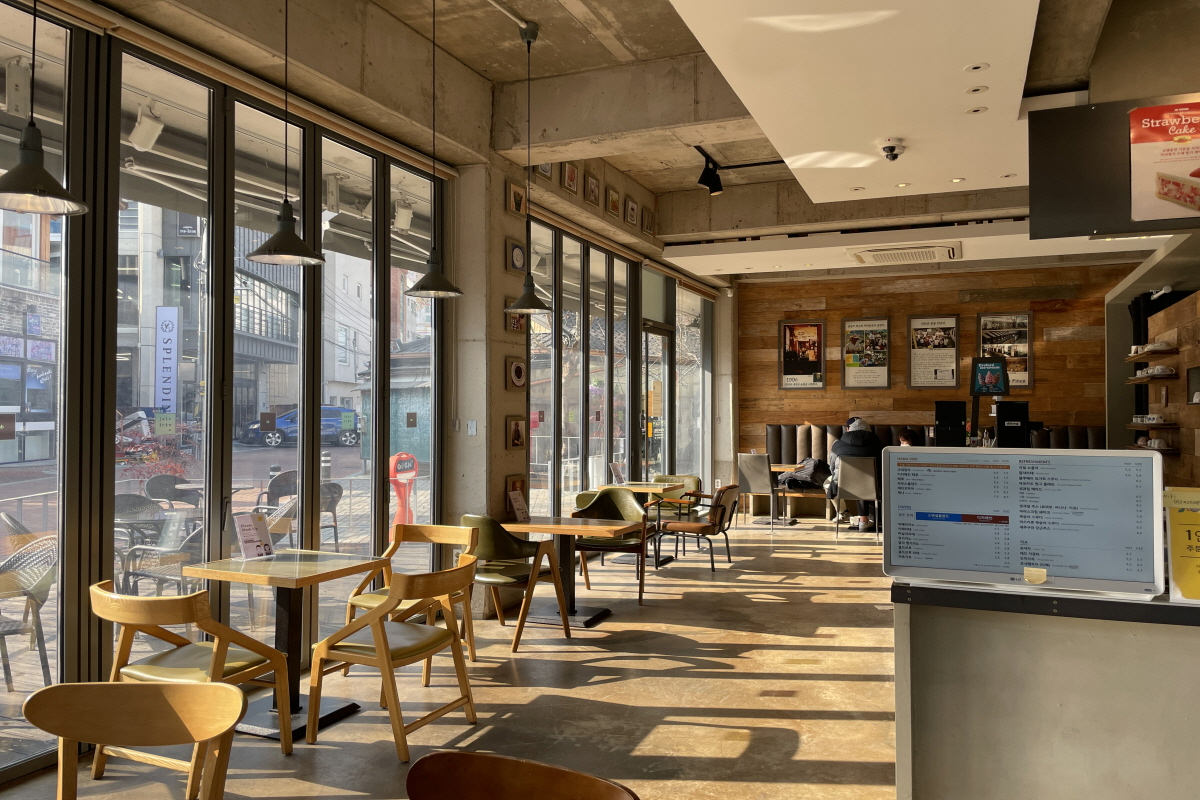 咖啡明家EXCO店的入口，位於一棟頗為現代的建築物中