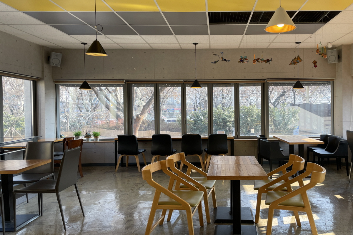 咖啡明家EXCO店內部的餐飲區域，裝潢簡約，設有多個桌椅供顧客使用