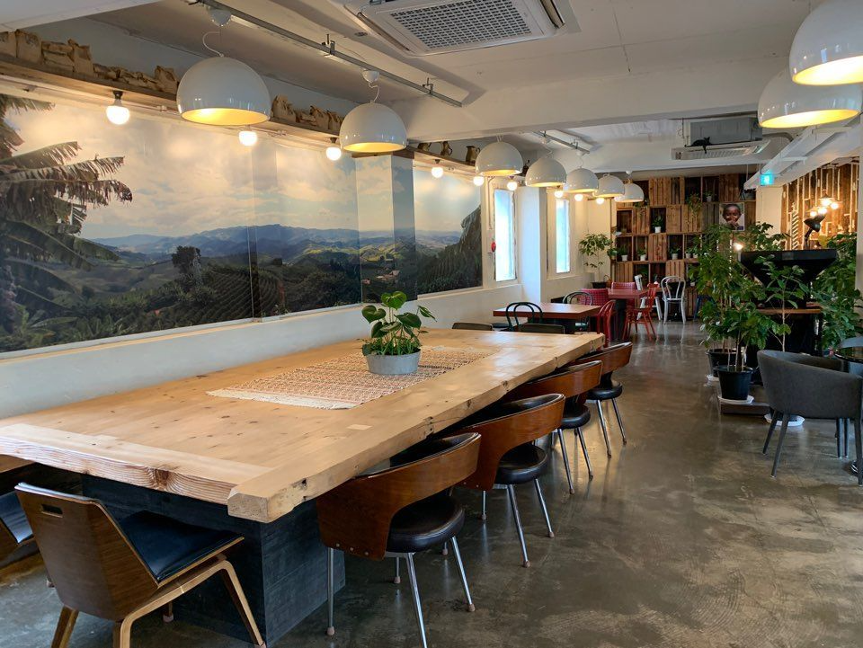 咖啡明家La Finca店的內部，擺放著大型木製餐桌和多個座椅