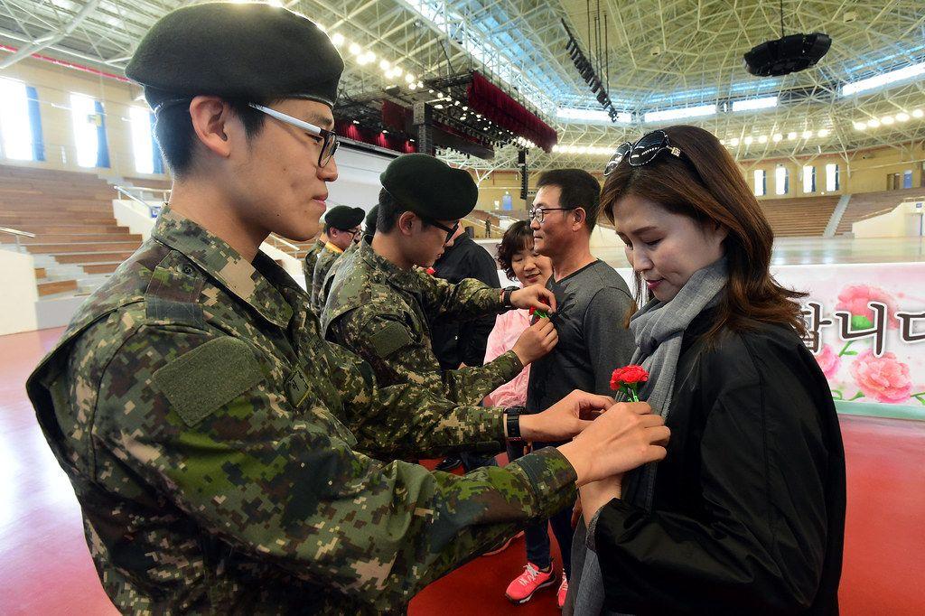 韓國士兵正在為父母佩戴康乃馨，這是韓國父母節（어버이날）傳統中表達感謝的象徵。