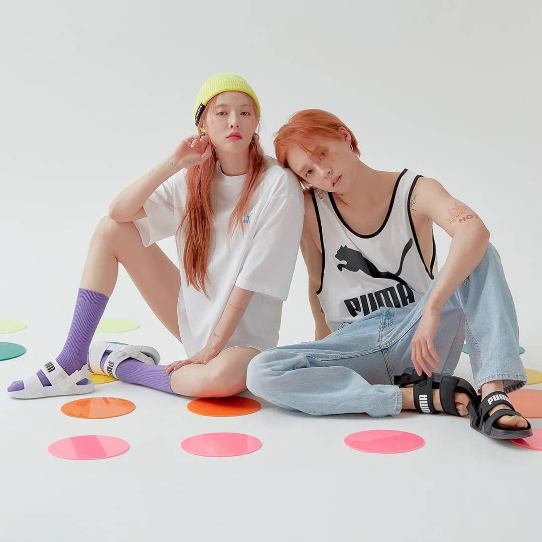 韓國PUMA涼鞋展示，兩名模特兒穿搭黑、白涼鞋坐於粉色背景，風格清新簡約。