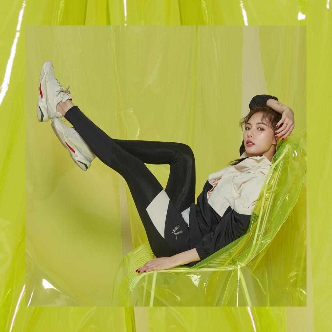泫雅在鮮黃色佈景中展示復刻版PUMA厚底鞋，搭配黑色運動緊身褲，呈現獨特的摩登風格。