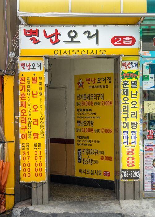 Entrance of Special Duck Restaurant in Dongdaemun, displaying menu prices.