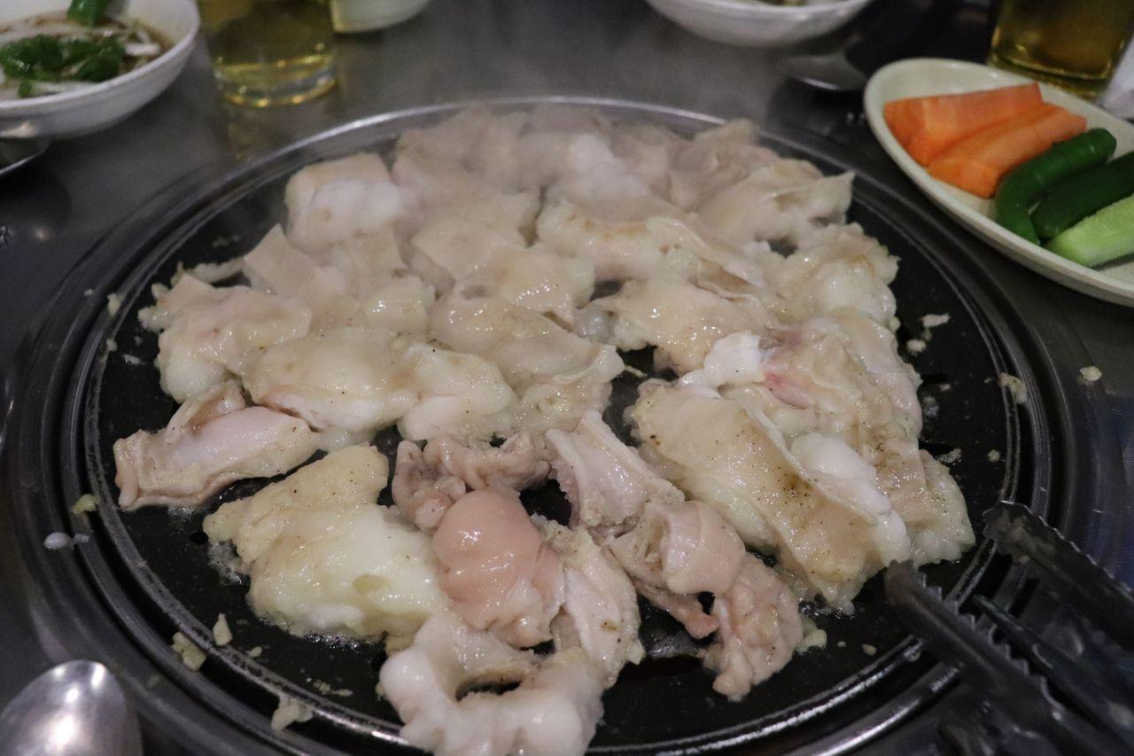 正在烘烤的韓牛內臟，配有新鮮的大蒜增添香味。