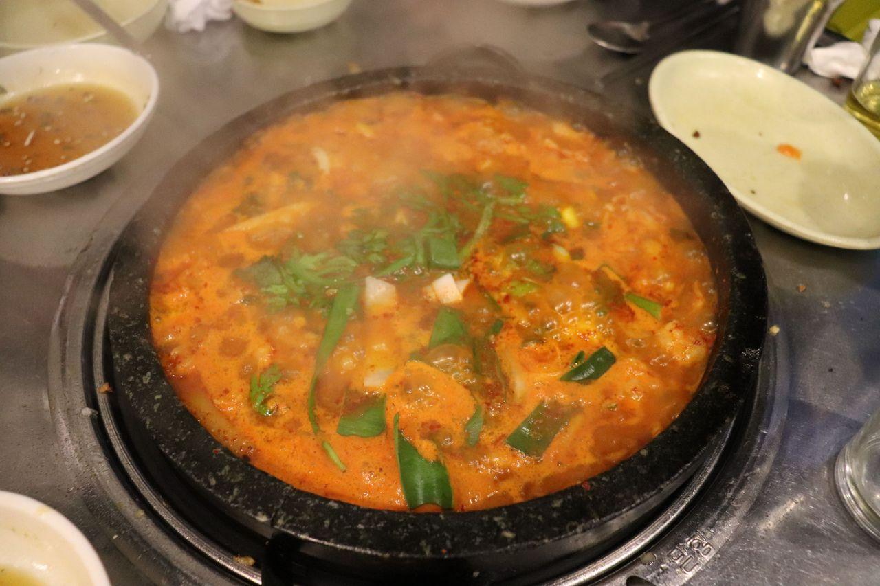 肥腸鍋表面的泡沫和紅潤的湯汁，顯示出豐富的味道。