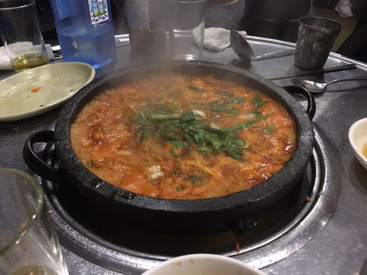 筷子上夾著熟透的牛腸，顯示豐富的油脂和香氣。