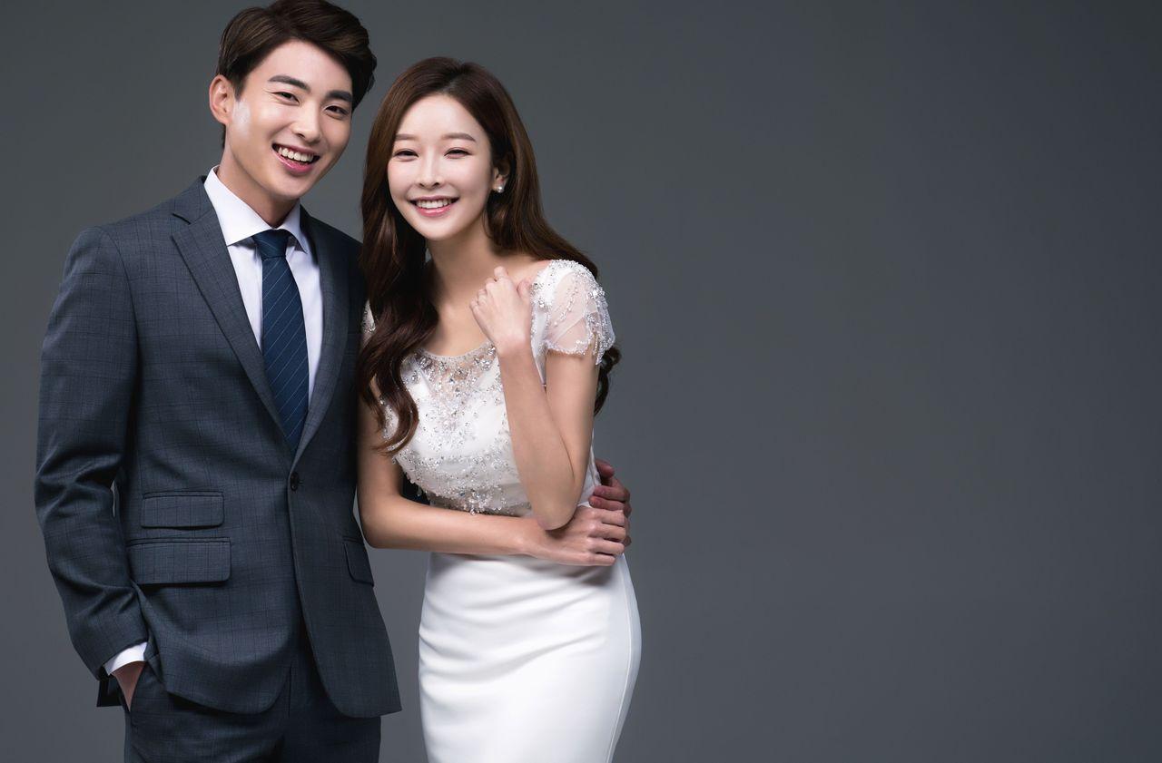 Wedding couple in elegant formal wear standing together, showcasing the classic style of Korean wedding photography.