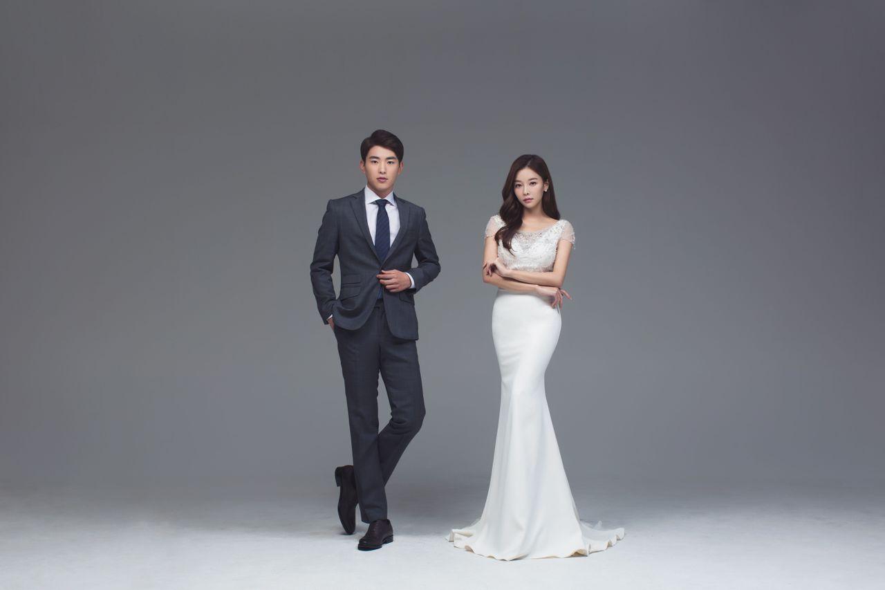 Bride and groom posing in wedding outfits, highlighting the simplicity and elegance of Korean wedding photography.