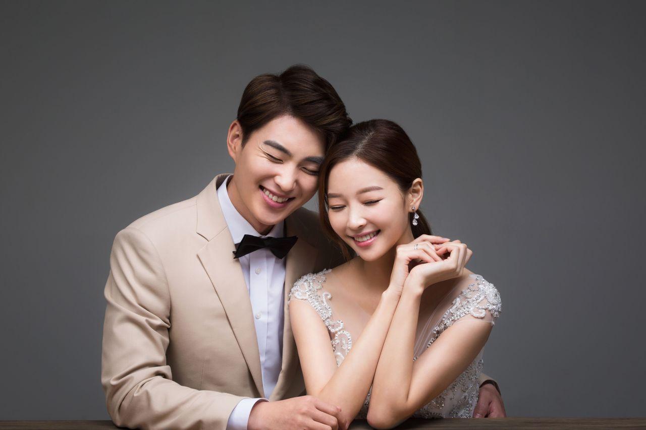 Couple in formal wear sitting with a bouquet, illustrating a sophisticated yet relaxed wedding photo atmosphere.