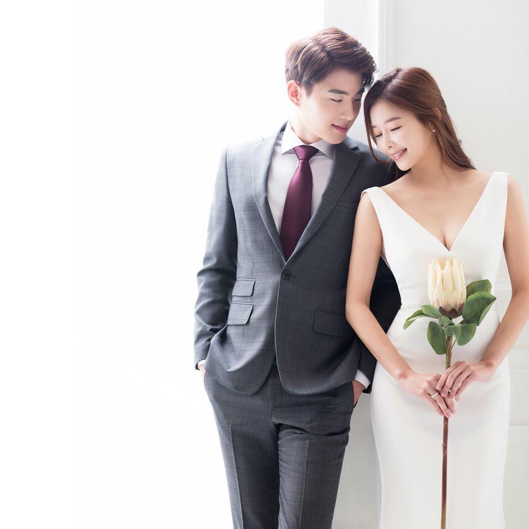 Groom wearing a formal suit in a reflective portrait, capturing the chic and contemplative side of wedding photography.