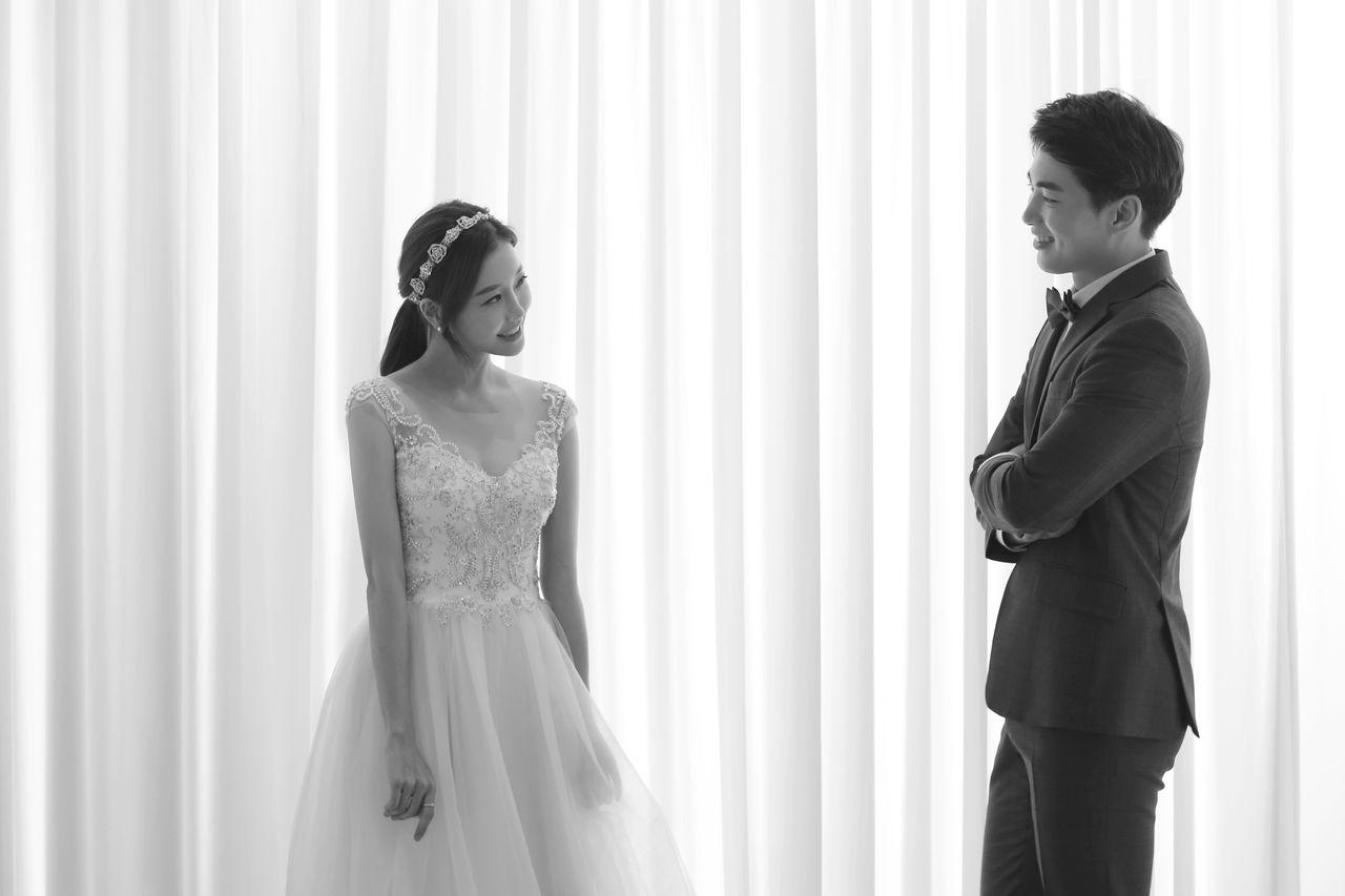 Couple in colorful, stylish outfits holding flowers, representing a playful and modern twist in Korean wedding photography.