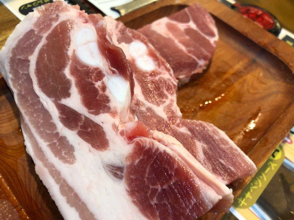 一块新鲜生肉在砧板上，韩国入境申报需注意的食品。