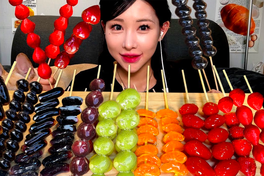 Assortment of brightly colored Korean Tanghulu skewers, fruit glazed with sugar, a popular sweet street treat.