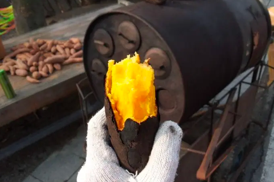 Korean roasted sweet potato, peeled to show its bright orange flesh, a popular warm street food snack.
