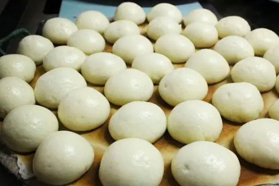 Assorted steamed Korean buns displayed on a tray, ready to be served as a street food snack during cooler seasons.
