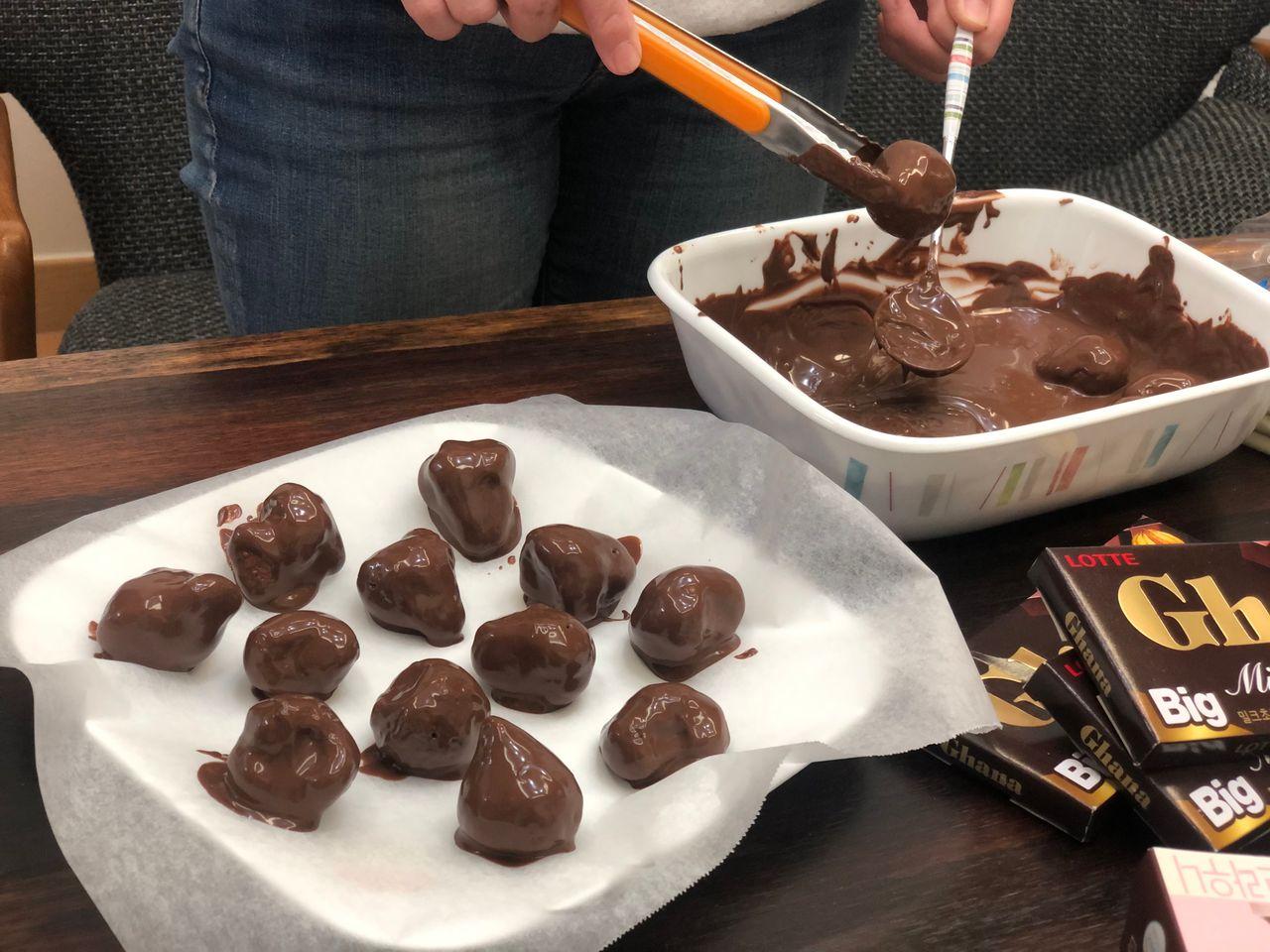 將糯米粉巧克力撒在自製手工士多啤梨巧克力上，為甜點增添心思和風味。