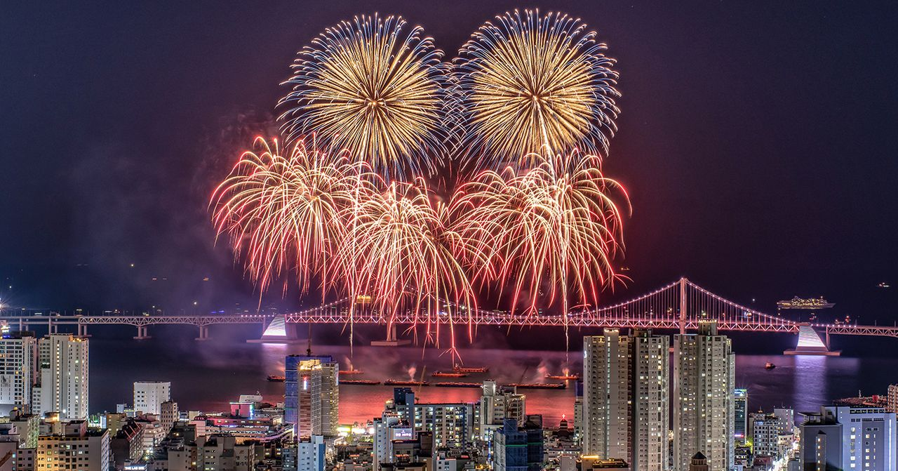 釜山煙花盛會，在夜空中綻放的煙花瀑布，背景是釜山大橋。