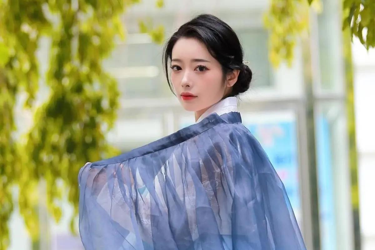 A model displaying a special hanbok, featuring a sophisticated, layered design with rich textures, ideal for formal occasions, set against a backdrop of traditional Korean architecture.
