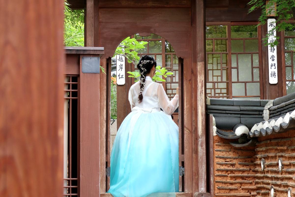 A sophisticated hanbok showcasing layers of soft hues and elegantly tied ribbons, perfect for tourists looking to capture moments of cultural authenticity.