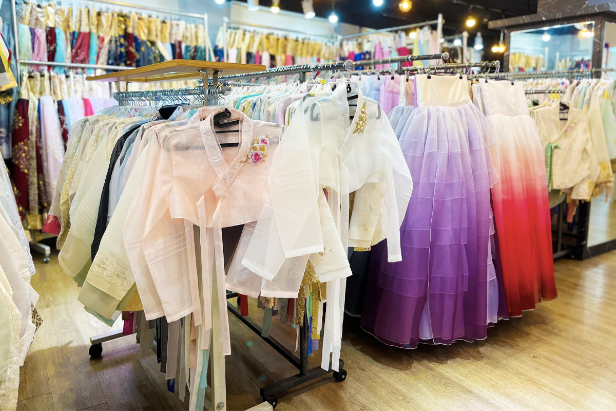 A panoramic view of Princess Hanbok store, highlighting the extensive range of traditional Korean costumes, meticulously hung and ready for rental by visitors exploring cultural wear.