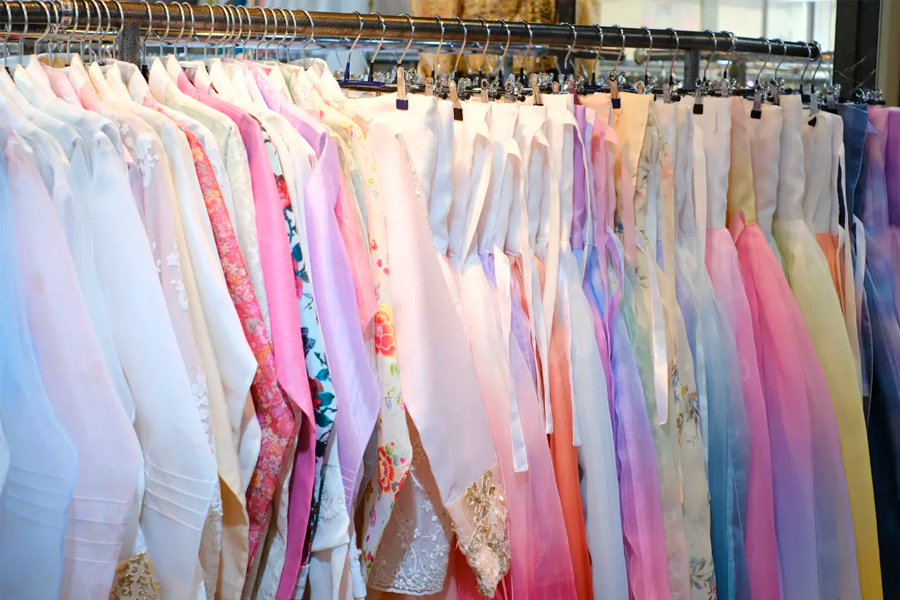 Row of colorful hanboks highlighting the diverse range of styles available at Princess Hanbok rental near Gyeongbokgung.