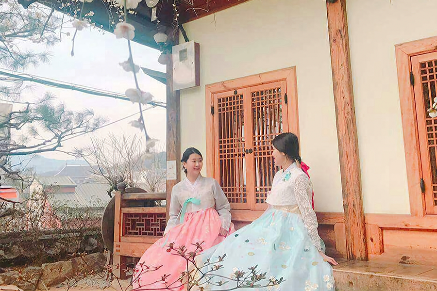 Visitors enjoying Korean traditional hanboks in an exquisite hanok setting at Gyeongbokgung in Seoul.