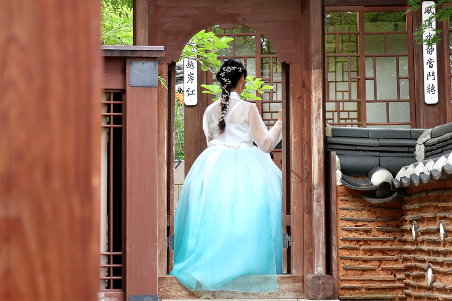 Charming scenery at a Korean traditional palace garden, featuring individuals in vibrant hanboks, adding cultural flair.