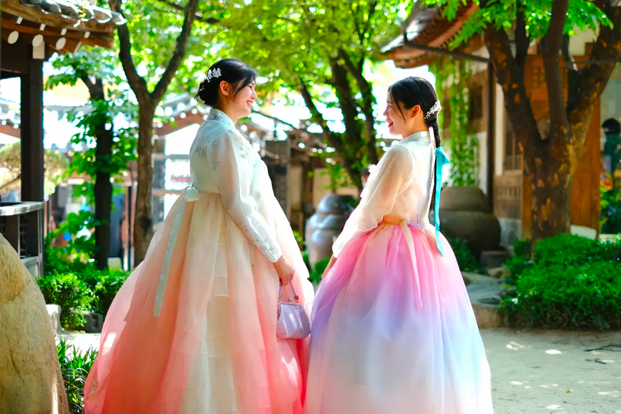 Captivating image of individuals wearing hanboks in a beautifully preserved courtyard at Bukchon Hanok Village.