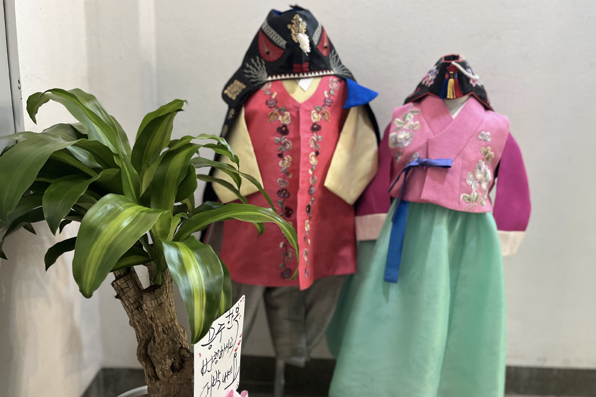 An inviting storefront of Princess Hanbok, showcasing a colorful array of traditional Korean dresses and accessories, housed in a spacious retail area with a warm ambiance.