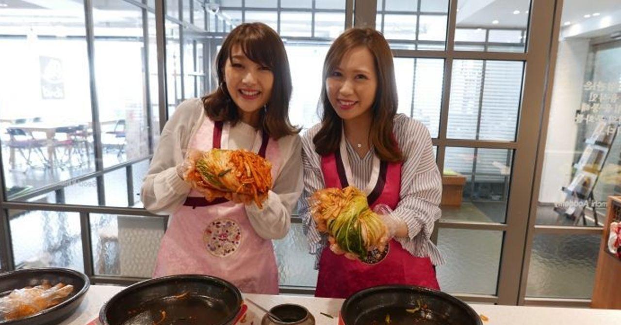 在韩国首尔的泡菜制作体验，参与者展示刚制成的传统韩国泡菜。