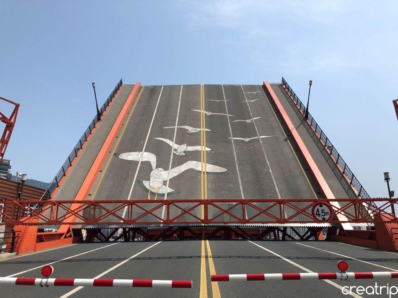 釜山知名地標影島大橋的一角，橋面上繪有海鷗圖案，背景是藍色天空。