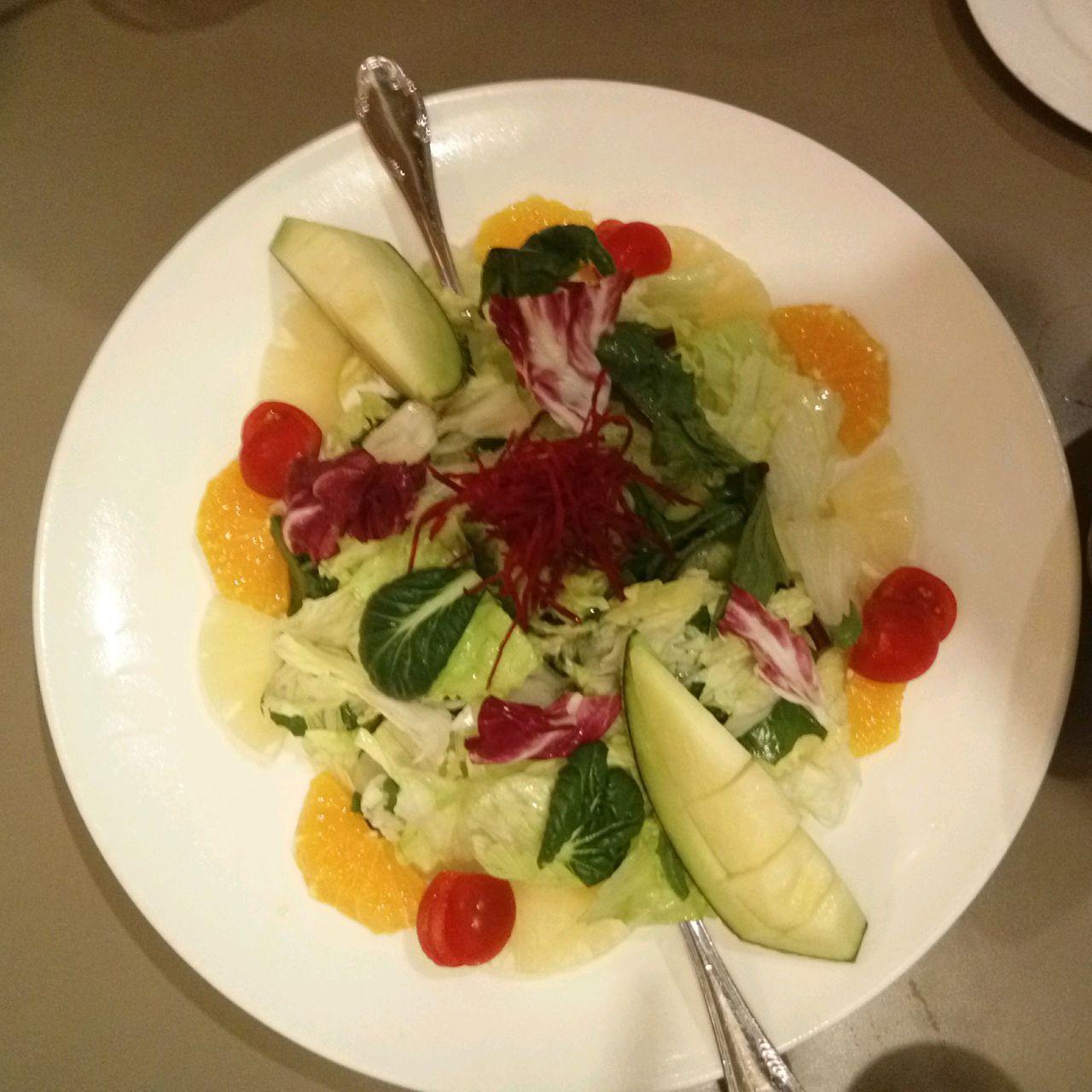 釜山LEE JAE MO披薩旁的水果沙拉，色彩鮮豔，包含蔬菜、西紅柿和切塊水果。