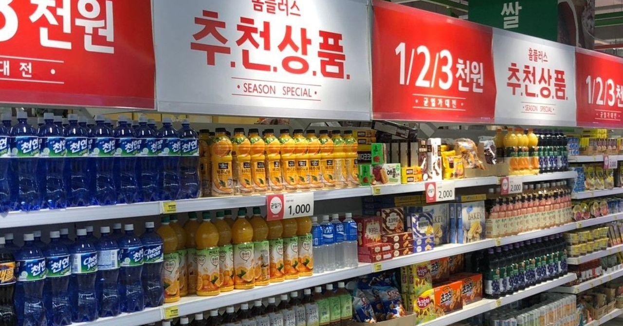 弘大homeplus，貨架上陳列的飲料商品，顯示促銷標誌。