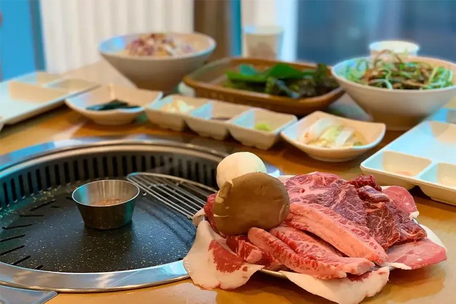 韓國美食的一頓燒烤餐，桌上擺滿了肉品和各種韓國傳統小菜。