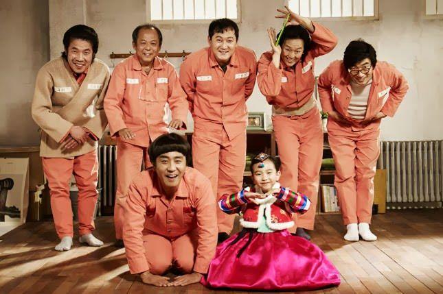 韩国电影《七号房的礼物》，表现角色集体幽默的情境。