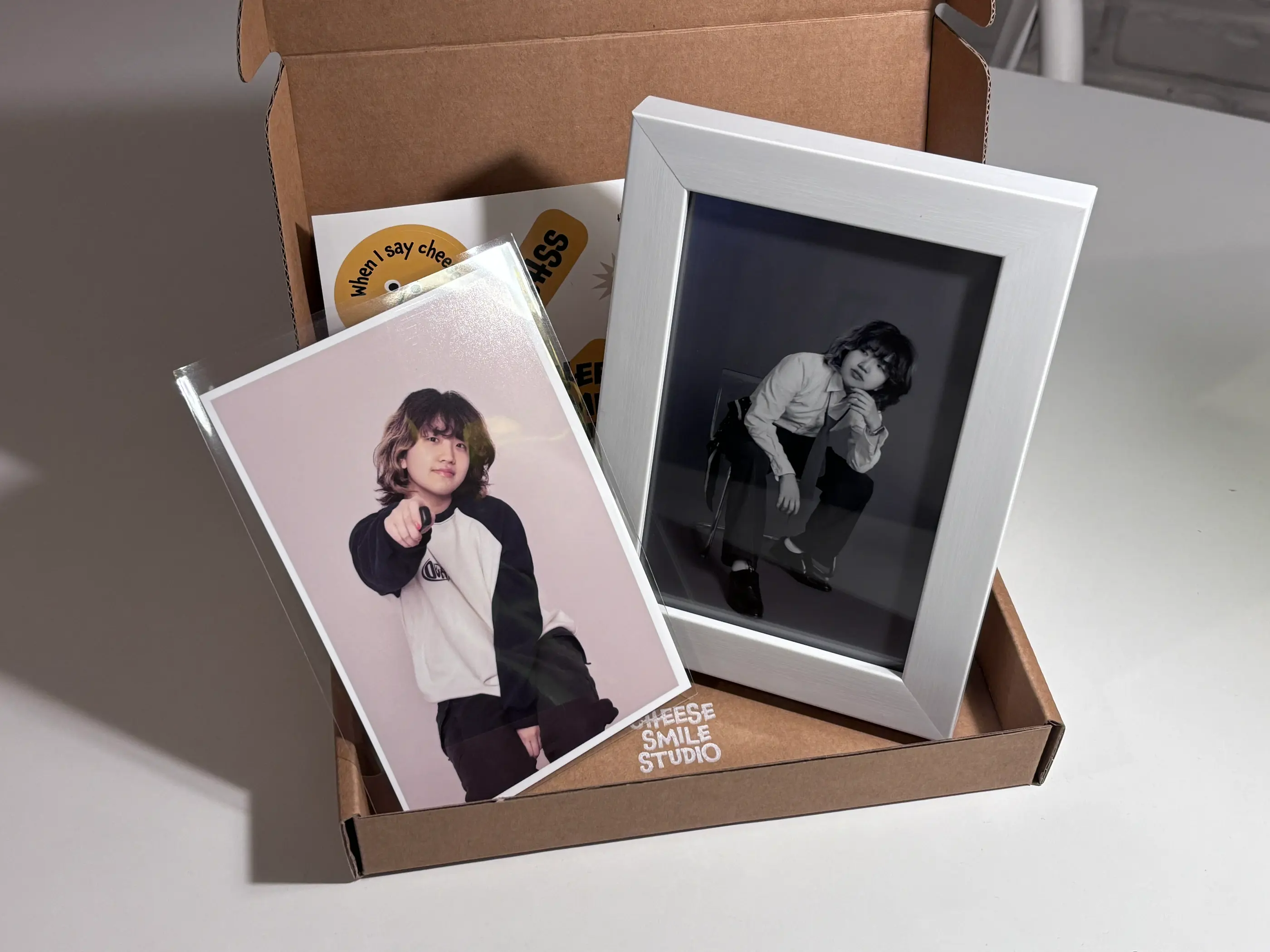 Cheese Smile Studio提供的兩張完成後的照片及白色相框供顧客選擇帶走。