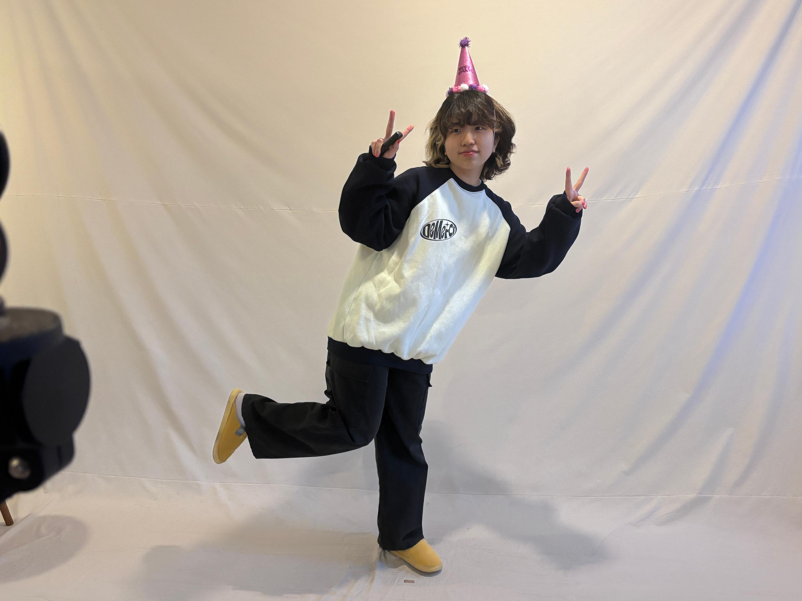 顧客穿著黑白對比的運動上衣，在Cheese Smile Studio內擺姿勢進行自助拍攝。