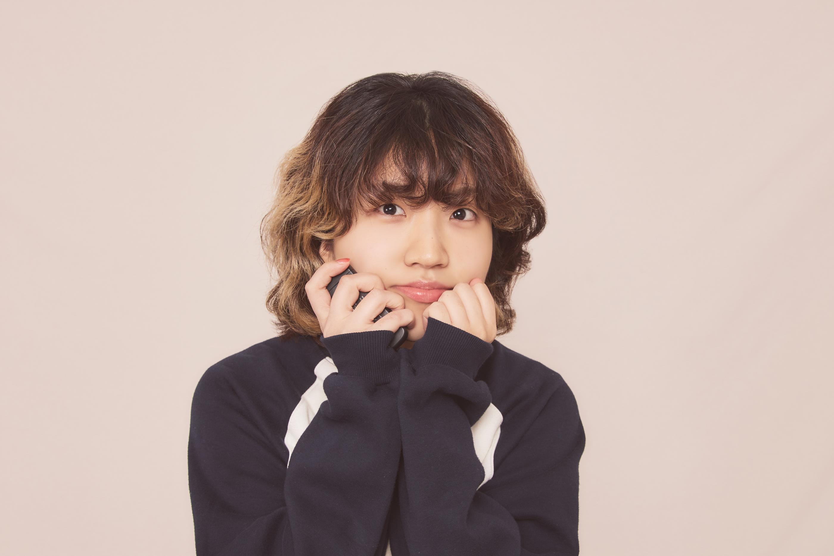 穿著深色服裝的顧客，正在Cheese Smile Studio內拍攝，背景為灰色背景布。