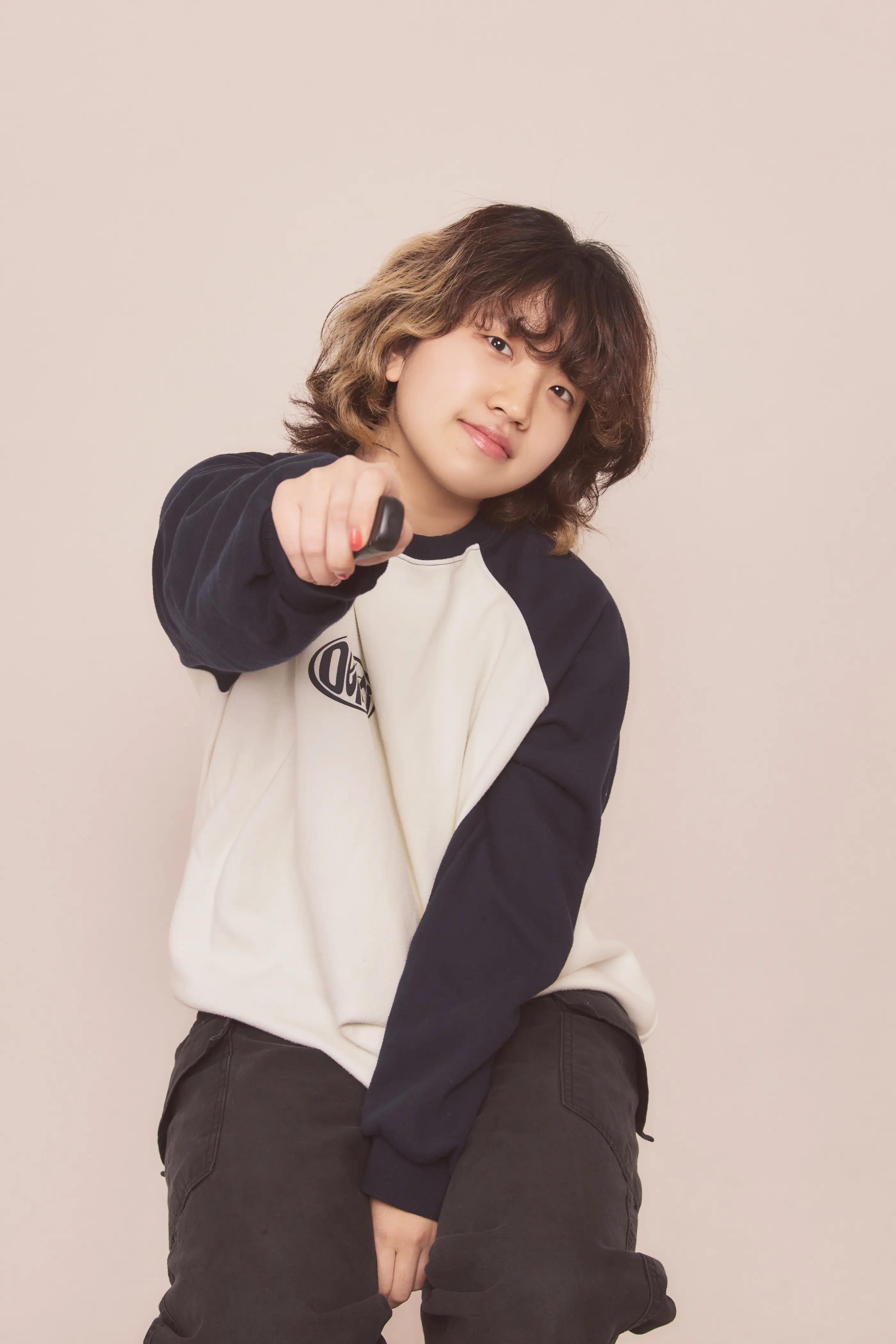 チーズスマイルスタジオでポーズをとる人物。カジュアルな服装とスニーカーを履いています。