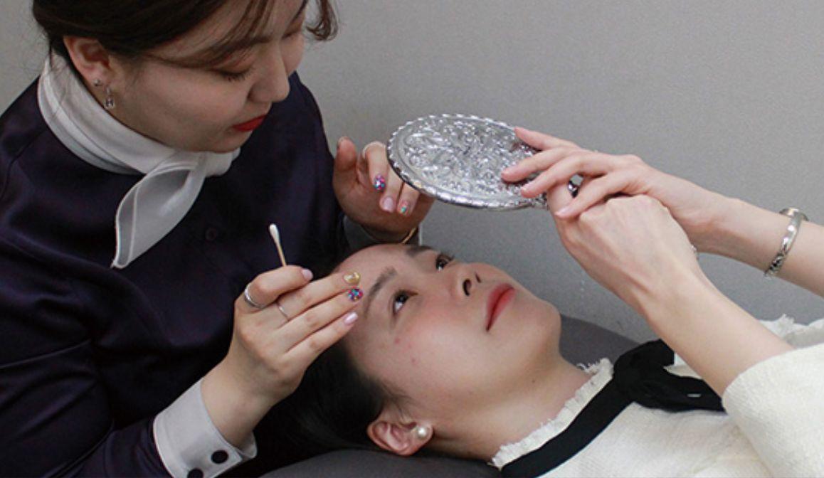 Reviewing the results of a semi-permanent eyebrow procedure at Juliet Beauty in Busan.