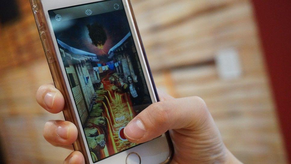 手機屏幕顯示的特麗愛美術館AR效果, 擴增實境中看到生動的火山熔岩場景