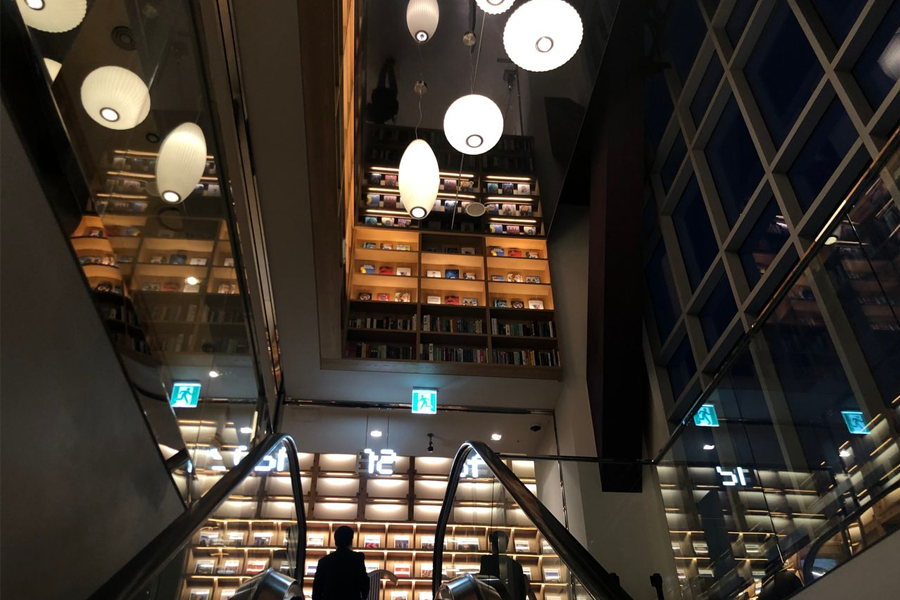 新村Arc.N.Book书店的室内环境,现代设计的书架和电梯,灯光照亮空间,充满现代感。