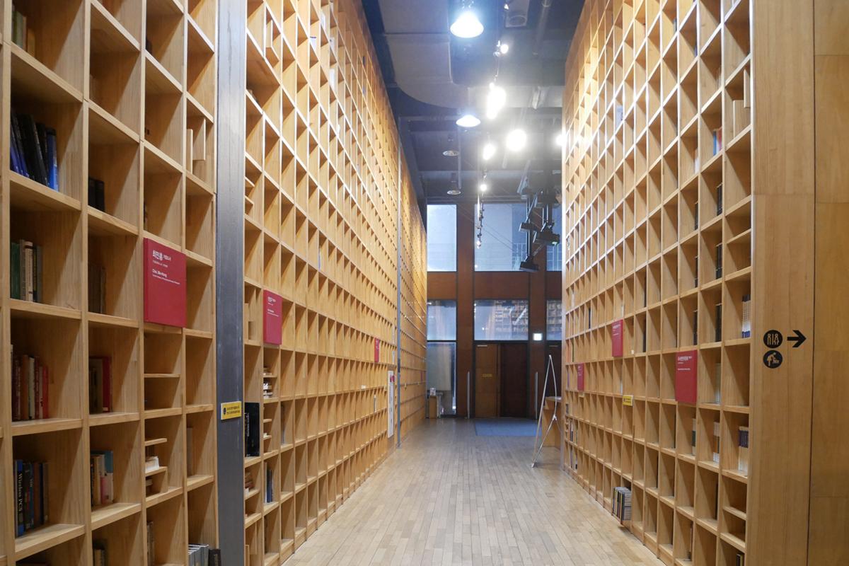 智慧之林图书馆的走廊,木质书架整齐排列,灯光柔和。