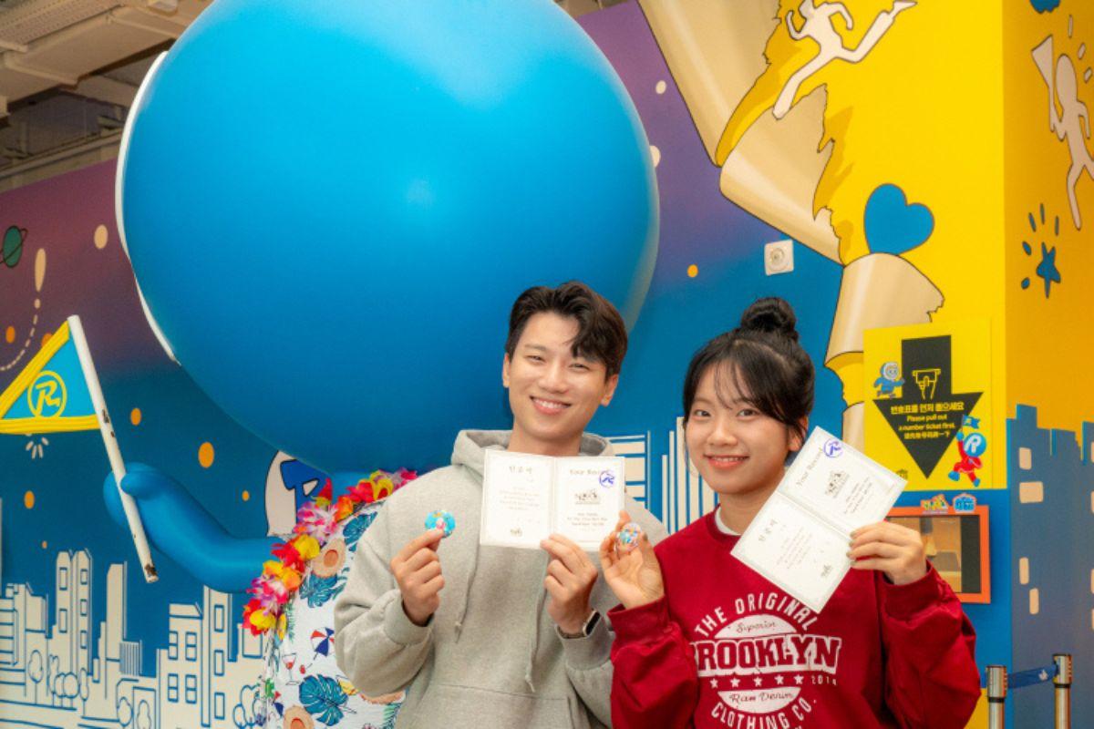 兩位遊客在釜山Running Man體驗館中展示獲得的證書和禮物