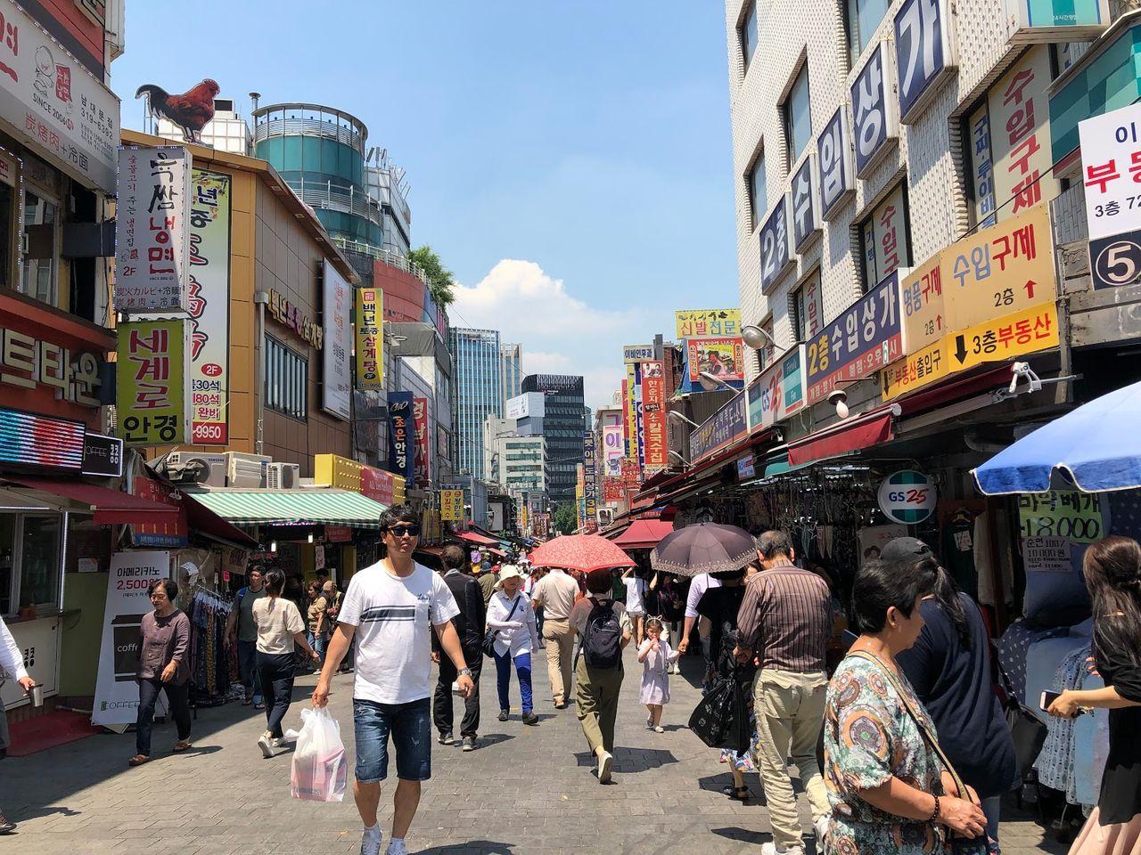 南大門市場的街景，衣服店和人群的擁擠氛圍