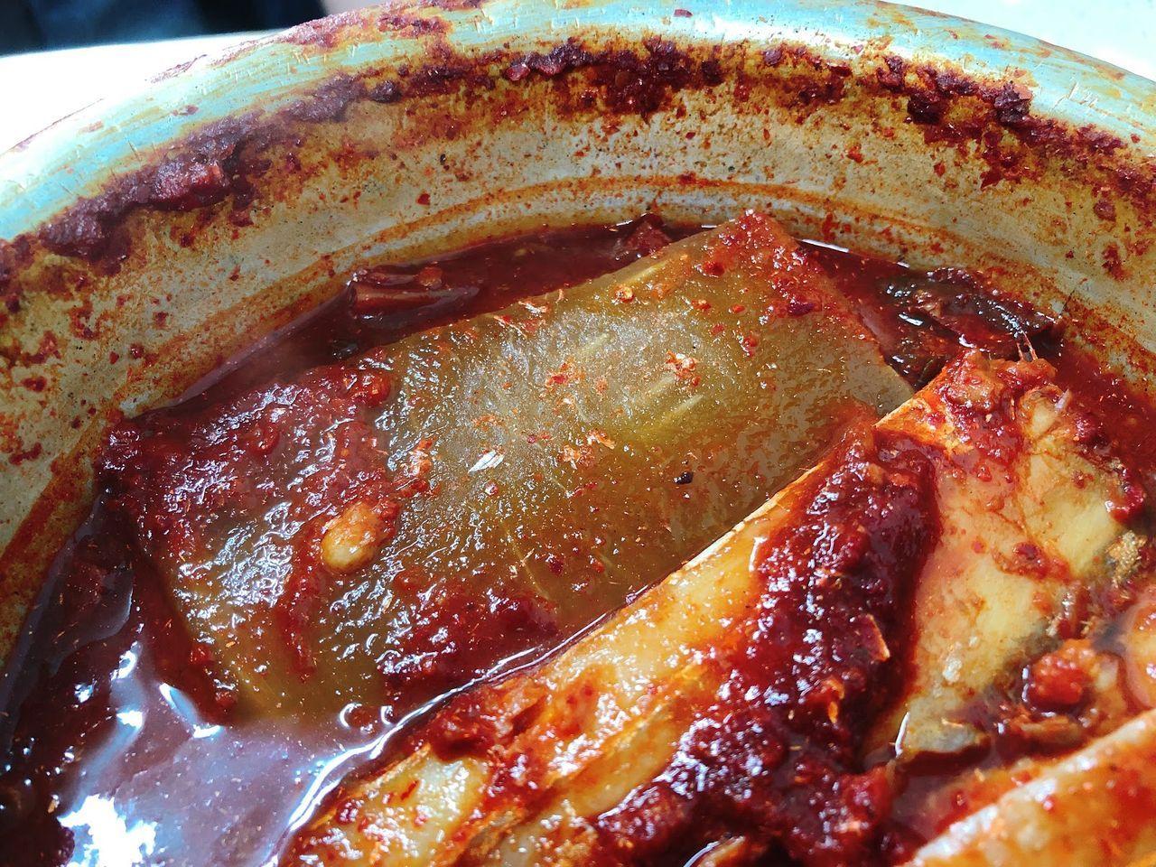 近拍韓國辣燉白帶魚，展示其香辣醬汁和配料