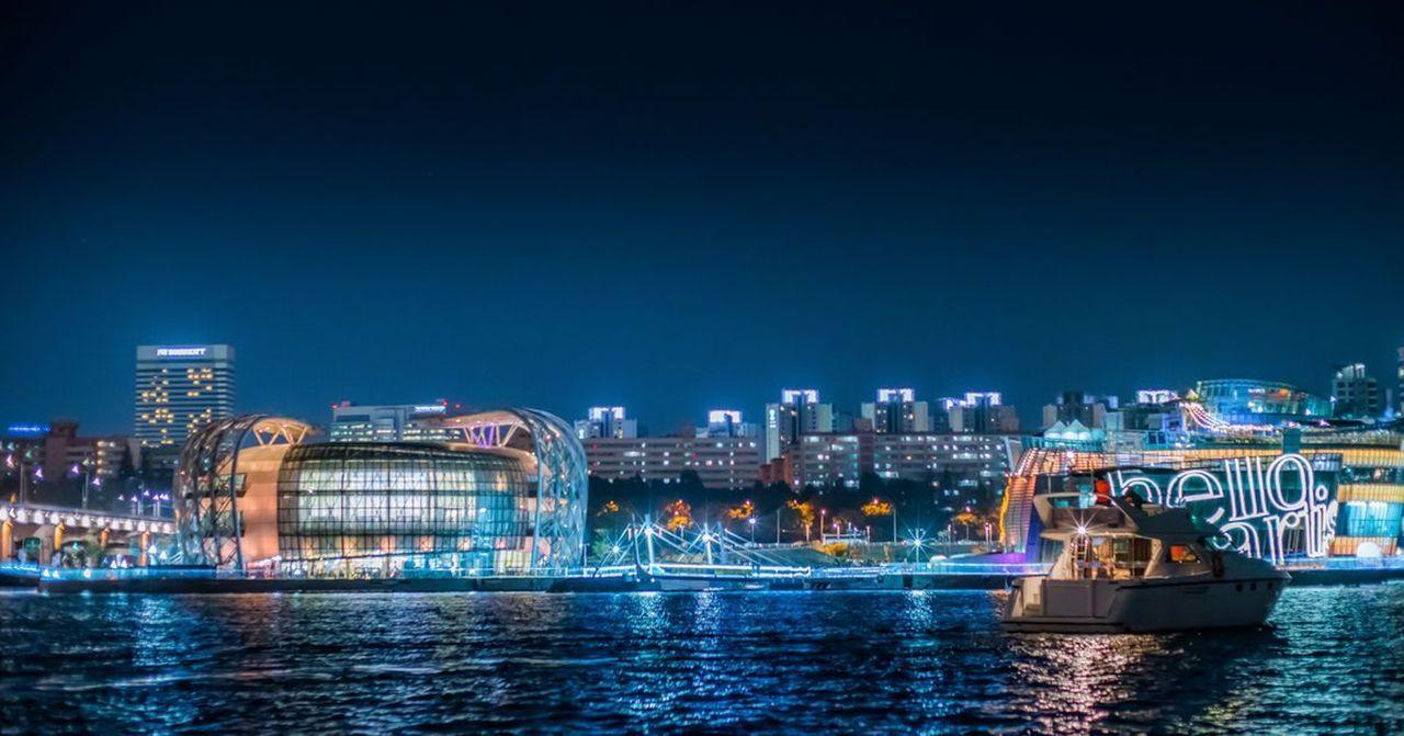 汉江夜景，霓虹灯闪烁，城市天际线与水面形成优美反射，动人夜间氛围。