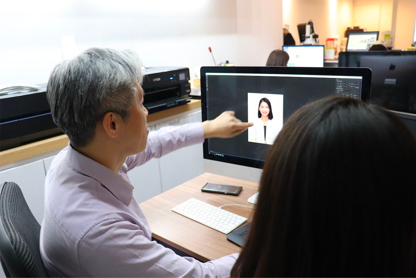 我們洞內照相館的修圖過程展示，專業攝影師正在指導照片修圖，提供優質的證件照服務。